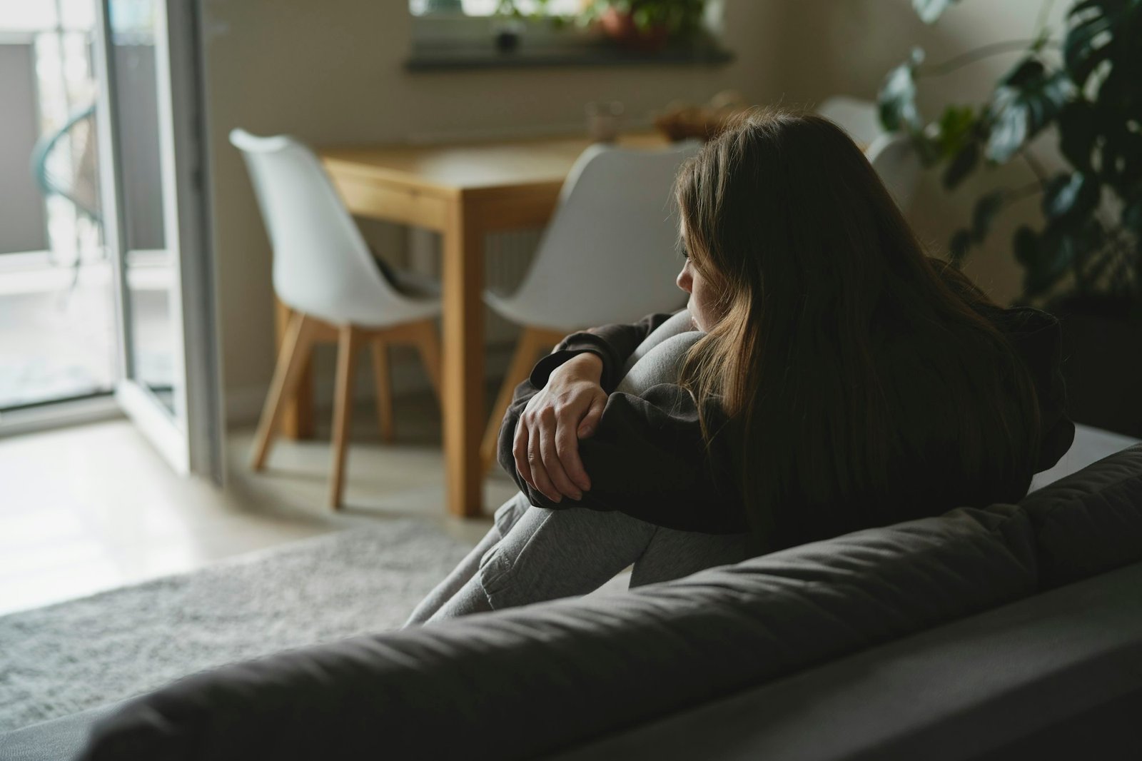 Caucasian sad woman sitting at the sofa with depression