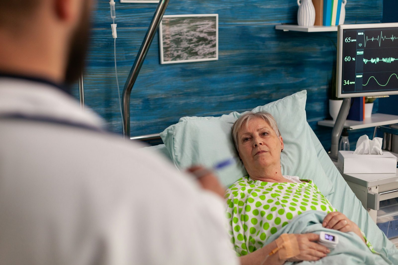 Elderly hospitalized woman being attended by doctor